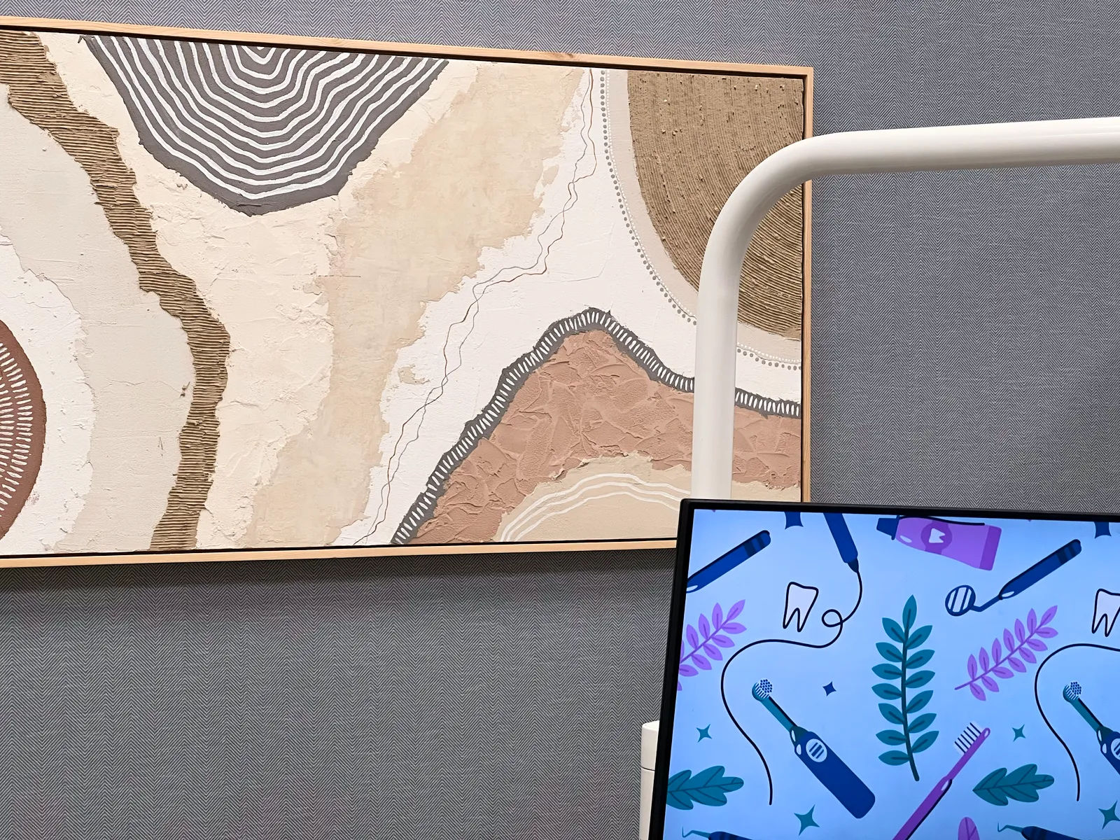 Treatment room with wall art and ceiling-mounted screen